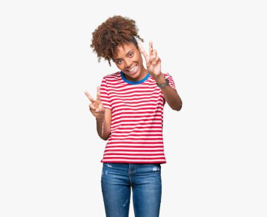 Güzel genç Afro-Amerikan kadın parmaklarını zafer işareti yaparken gösterilen kamera seyir gülümseyen izole arka plan yüzünden. İki numaralı.