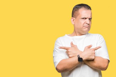 Orta yaş Arap adam wearig beyaz t-shirt üzerine izole arka plan için her iki parmak, farklı yönde ile katılmıyorum işaretleme