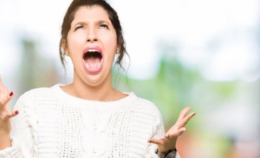 Kış kazak çılgın ve kızgın bağırarak ve agresif ifade ve silah kaldırdı bağırmaya giyen genç güzel kadın. Hayal kırıklığı kavramı.