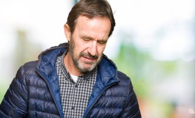 Orta yaş yakışıklı adam elini karnına giyen kış paltoyla çünkü hazımsızlık, ağrılı hastalık hasta hissediyor. Ağrısı kavramı.