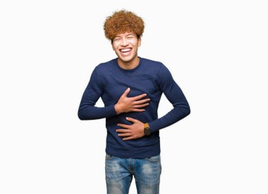 Afro saç ile genç yakışıklı adam gülümsüyor ve sert yüksek sesle gülüyor Çünkü komik çılgın şaka. Mutlu ifade.