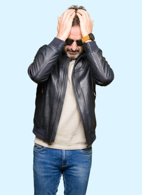 Güneş gözlüğü ve çünkü umutsuz ve stresli baş ağrısı acı siyah deri ceket giyen orta yaş yakışıklı adam ağrı ve migren. Ellerini kafasına.
