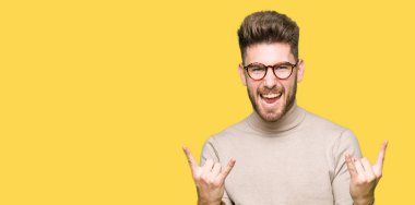 Genç yakışıklı iş adamı deli ifade rock simge elle yapıyor ile bağırarak gözlük takıyorum. Müzik yıldızı. Ağır kavramı.