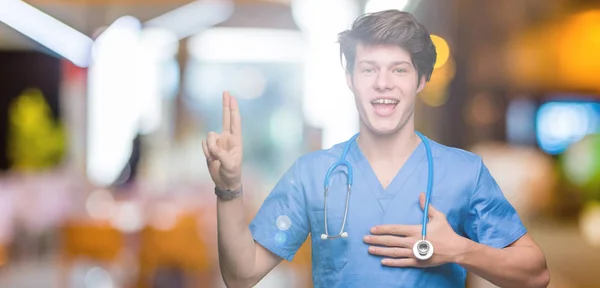 Young doctor wearing medical uniform over isolated background Swearing with hand on chest and fingers, making a loyalty promise oath