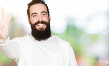 Uzun saç ve sakal gösterilen ve parmakları ile işaret sportif sweatshirt giyen genç adamla üçüncü ise kendinden emin ve mutlu gülümseyerek.