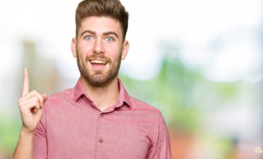 Genç yakışıklı iş casual başarılı fikirle yukarı işaret parmağı dostum. Çıktıktan ve mutlu. Bir numara.