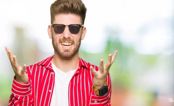 Young Handsome Man Wearing Sunglasses Celebrating Mad Crazy Success Arms — Stock Photo, Image