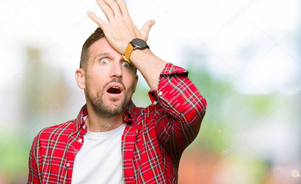 Handsome man wearing casual shirt surprised with hand on head for mistake, remember error. Forgot, bad memory concept.