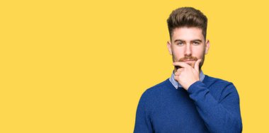 Çapraz kollar ve çeneme kaldırdı el ile gülümseme ile kamera kendinden emin görünen genç yakışıklı iş adam. Pozitif düşünce.