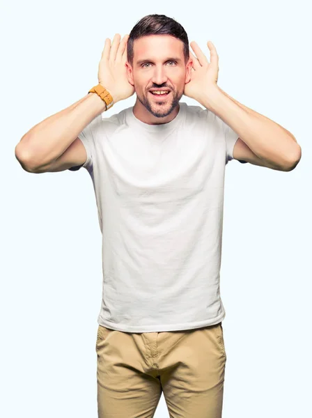 Hombre Guapo Usando Una Camiseta Blanca Casual Tratando Escuchar Ambos —  Fotos de Stock