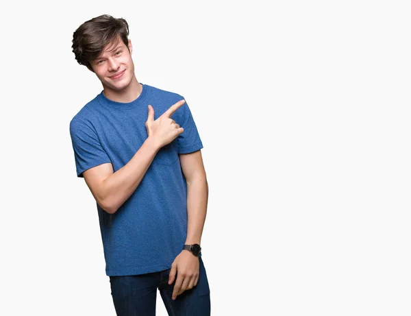 年轻的帅哥穿着蓝色的 T恤在孤立的背景欢快 微笑着用手和手指指着一边 脸上带着快乐和自然的表情 — 图库照片