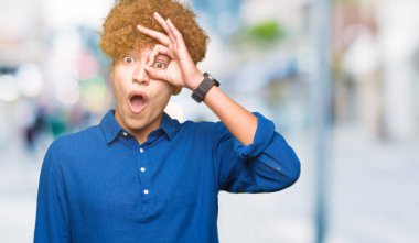 Afro saçlı Genç yakışıklı zarif adam sürpriz yüz ile şok ok jest yapıyor, göz parmaklar bakarak. İnanılmaz ifade.