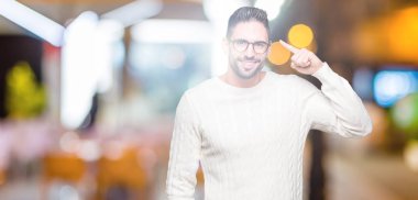 Genç yakışıklı adam gözlük izole üzerinde bir parmak, harika bir fikir ya da düşünce, iyi hafıza ile baş gösteren gülen arka plan