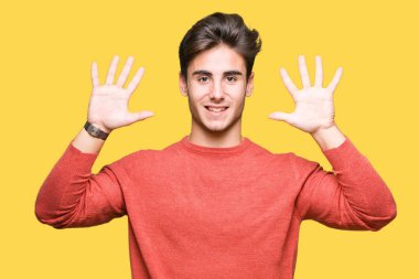 Yakışıklı delikanlı gösterilen ve parmakları ile işaret izole arka plan üzerinde kendinden emin ve mutlu gülümseyerek süre on numara.