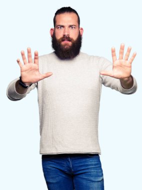 Genç Sarışın giyen sıradan kazak korkuyor ve korku ifade dur hareketi el ile ile dehşete şokta bağıran adam. Panik kavramı.