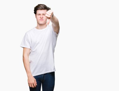 Mutsuz ve kızgın ret gösterilen ve başparmak aşağı hareketi ile negatif seyir izole arka plan üzerinde rahat beyaz t-shirt giyen genç yakışıklı adam. Kötü ifade.