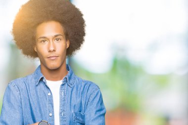 Afrikalı-Amerikalı genç afro saçlı gevşek yüzünde ciddi bir ifade ile. Basit ve doğal kameraya bakıyor.