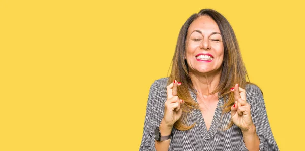 美しい中年女性実業家の希望と目を閉じて交差指の笑みを浮かべてします 運と迷信的な概念 — ストック写真