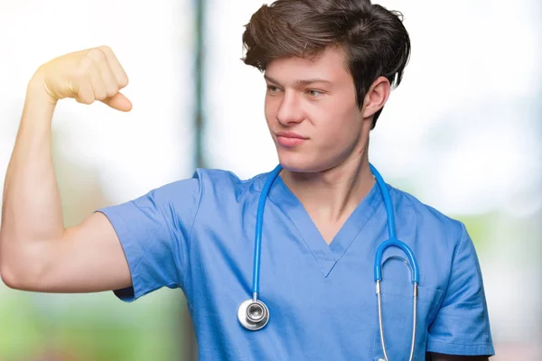 年轻医生穿医服在孤立的背景强人显示手臂肌肉 自信和自豪的力量 — 图库照片