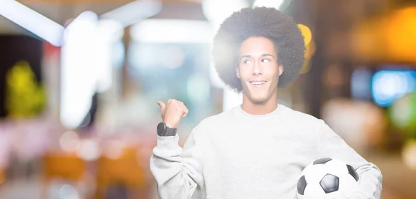 Молодий Афроамериканець Людиною Афро Волосся Тримаючи Футбольний Футбол Вказуючи Показуючи — стокове фото
