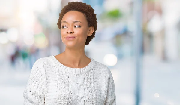 美丽的年轻非洲裔美国妇女穿着毛衣在孤立的背景微笑看一边 盯着思考 — 图库照片