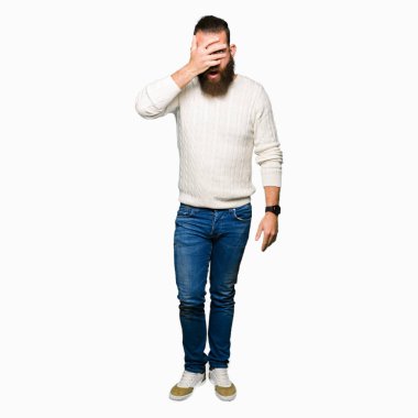 Kış kazak giyen genç hipster adam el ile yüz ve gözler kapsayan şok göz, utanmış ifade ile parmaklar bakarak.