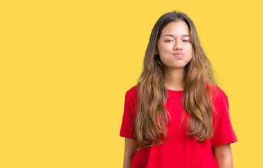 Komik surat ile yanakları şişirme izole arka plan üzerinde kırmızı t-shirt giyen genç güzel esmer kadın. Ağız ile hava, deli ifade şişirilmiş.