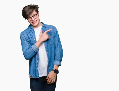 İzole arka neşeli bir gülümseme ile el ve parmak kadar yan yüzünde mutlu ve doğal ifade ile işaret yüz üzerinden gözlüklü genç yakışıklı adam