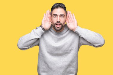 Her ikisi de dinliyoruz izole arka plan üzerinde sweatshirt giyen genç yakışıklı adam kulak jest, dedikodu için meraklı eller. İşitme sorunu, sağır