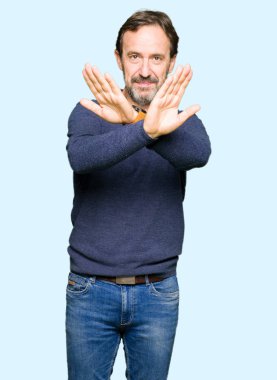 Orta yaş yakışıklı adamın geçiş bir kazak ret ifade giydiğini silah ve avuç içi eksi işareti, kızgın surat yapıyor