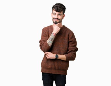 Emin çapraz kollar ve çeneme kaldırdı el ile gülümseme ile kameraya bakarak izole arka plan üzerinde kış kazak giyen genç yakışıklı adam. Pozitif düşünce.