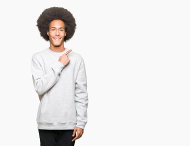 Sportif kazak neşeli bir gülümseme ile el ve parmak kadar yan yüzünde mutlu ve doğal ifade ile işaret yüz giyen afro saçlı genç Afro-Amerikan adam