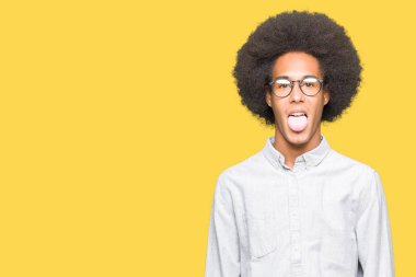 Afrikalı-Amerikalı genç afro saçlı gözlüklü dilini out komik ifade ile mutlu. Duygu kavramı.