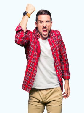 Rahat gömlek giyen yakışıklı adam öfkeli ve deli yükseltme yumruk sinirli ve öfke ile bağırırken öfkeli. Öfke ve agresif kavram.