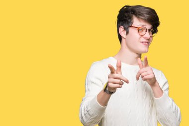 Fotoğraf makinesi ile mutlu ve komik yüz için parmakları işaret izole arka plan üzerinde gözlük takan yakışıklı delikanlı. İyi enerji ve vibes.