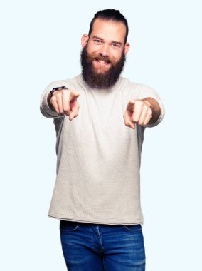 Casual kazak giyen genç sarışın adam sen ve kameraya gülümseyen pozitif ve neşeli parmaklarıyla işaret