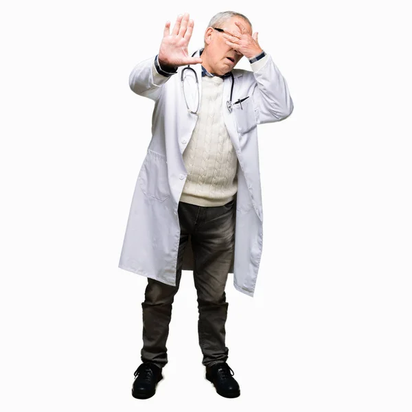 英俊的资深医生穿着医疗外套用双手捂住眼睛 用悲伤和恐惧的表情做停止手势 尴尬和消极的概念 — 图库照片