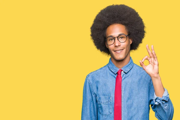年轻的非洲裔美国商人与非洲头发戴眼镜和红色领带微笑积极做确定的迹象与手和手指 成功的表达 — 图库照片