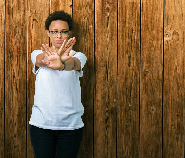 眼鏡をかけて分離背景除去式交差腕と手のひらの負の符号 怒った顔をしている美しい若いアフリカ系アメリカ人女性 — ストック写真