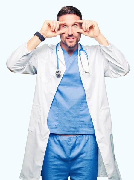英俊的医生在孤立的背景下穿着医疗制服试图用手指睁开眼睛 昏昏欲睡 因早晨疲劳而疲惫 — 图库照片