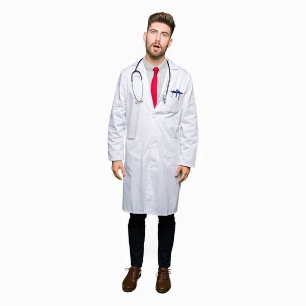 Young Handsome Doctor Man Wearing Medical Coat Shock Face Looking — Stock Photo, Image