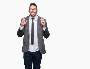 Genç yakışıklı iş adamı geçiş parmakları umut ve gözleri kapalı ile gülümseyen izole arka plan üzerinde. Şans ve batıl kavramı.