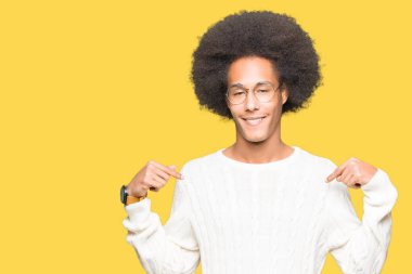 Yüzünde gülümseme ile kendinden emin görünüyorsun, kendini gururlu ve mutlu parmakları ile işaret gözlüklü afro saçlı genç Afro-Amerikan adam.