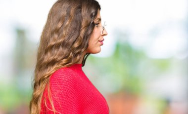 Tarafına, seyir kırmızı gözlük takan genç güzel kadın dinlenmek doğal yüz emin gülümseme ile pozuyla profili.