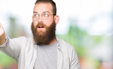 Gözlük takan genç sarışın adam parmak ile Işaret ileriye sürpriz, açık ağız hayran ifadesi, ön bir şey