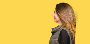 Yan için arıyorum güzel orta yaş kadın giyiyor kış yelek dinlenmek doğal yüz emin gülümseme ile pozuyla profil.