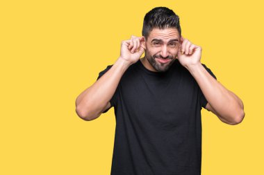 Yüksek sesle müzik gürültü rahatsız ifade parmaklarıyla kulaklarıyla kapsayan izole arka plan üzerinde genç yakışıklı adam. Sağır kavramı.