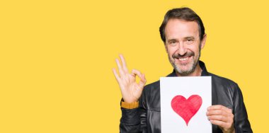 Parmak ile ok işareti yapıyor kırmızı kalp ile kağıt tutan yakışıklı Orta Çağ adam, mükemmel sembolü