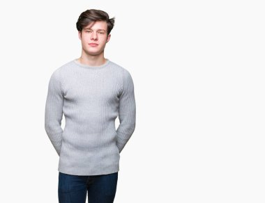 Üzerinde kış kazak giyen genç yakışıklı adam arka plan gevşek yüzünde ciddi bir ifade ile izole. Basit ve doğal kameraya bakıyor.