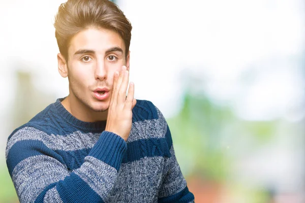 Joven Hombre Guapo Sobre Aislado Fondo Mano Boca Contando Rumores —  Fotos de Stock